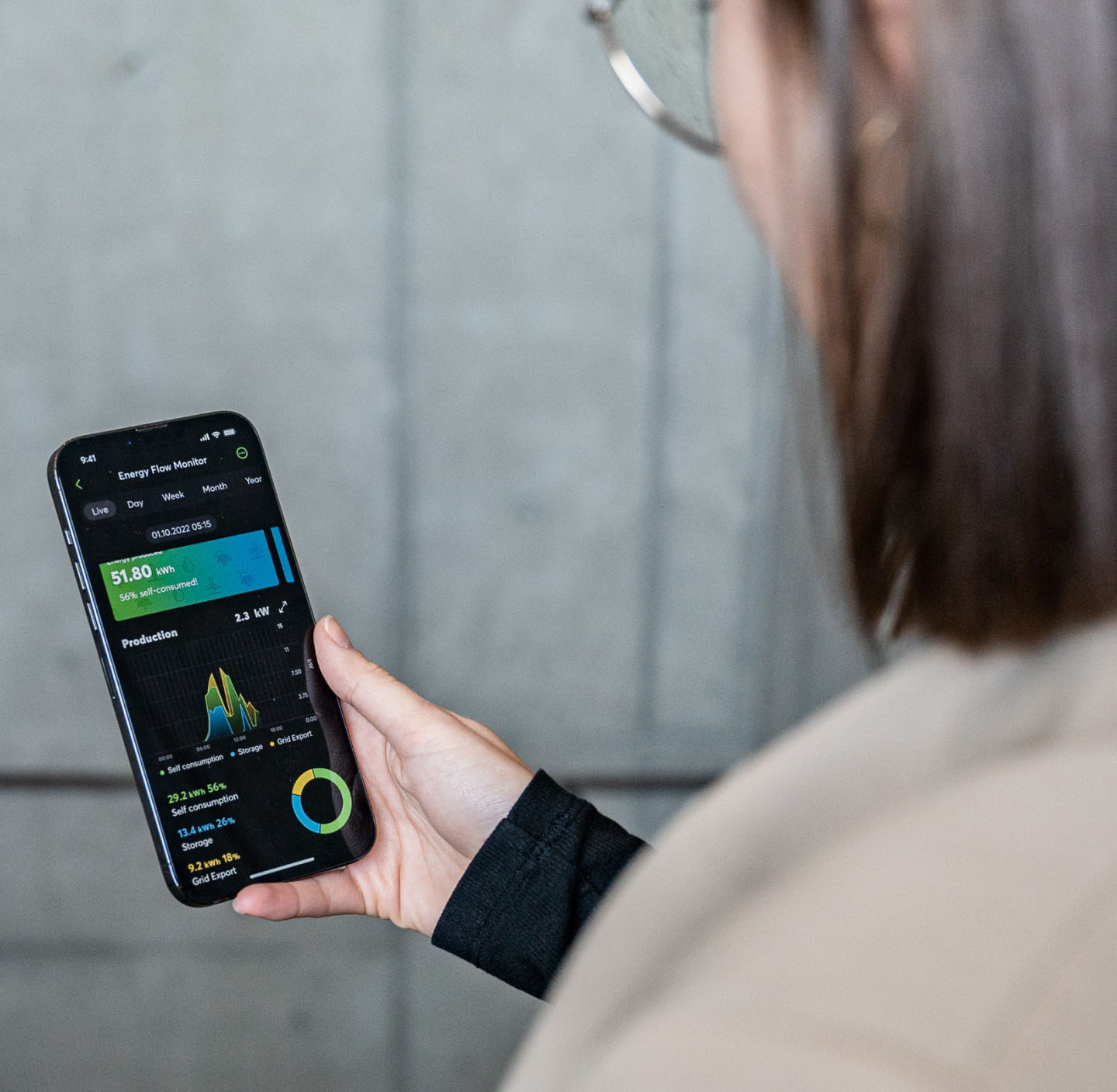 A woman looking at the Loxone App on a smartphone